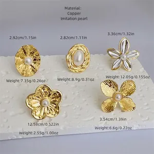 Five styles of 18K gold plated brass rings featuring textured floral designs and pearls