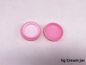 Detailed view of a 5g pink plastic cream jar showing the open base and lid components