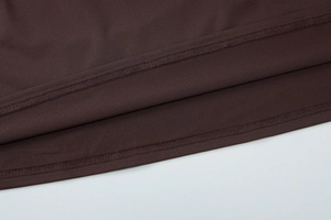 Detail shot of the reinforced double stitching on the brown dress fabric hemline