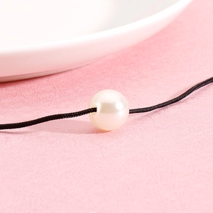 Minimalist love heart necklace featuring a single white pearl on a delicate black cord