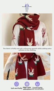 Detail of red Christmas scarf featuring reindeer jacquard knit and soft fringe texture