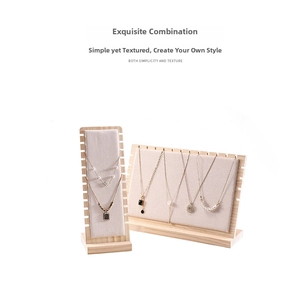 Macro detail of wooden necklace display stands with beige velvet lining and multiple slots