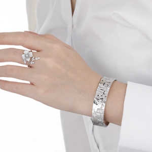 Floral S925 sterling silver ring and textured wide cuff bracelet set on a female model