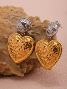 Macro detail of two-tone hammered heart earrings on a natural yellow stone base