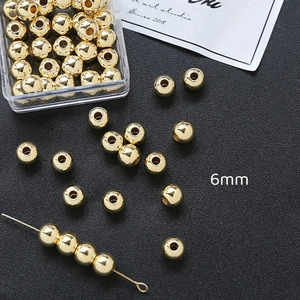 Detail van 6mm goudvergulde ronde tussenkralen met een transparante opbergdoos