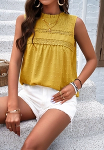 Close-up of yellow sleeveless top featuring delicate lace trim and Swiss dot fabric texture