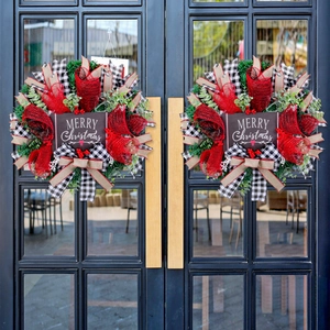 Christmas wreaths with red mesh, plaid ribbons, and Merry Christmas signs on black doors