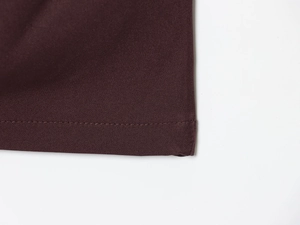 Detail shot of hem stitching on dark brown sleeveless bodycon dress fabric