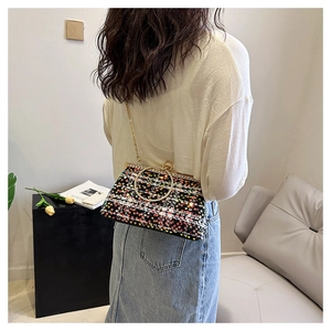 Detail of colorful sequins and metal ring handle on a tweed chain crossbody evening bag