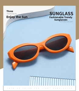 Detailed view of orange oval sunglasses with dark lenses on a geometric aesthetic background