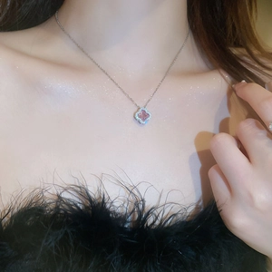 Macro shot of pink clover pendant with sparkling crystal halo on silver chain