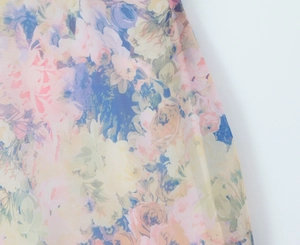 Detailed macro view of colorful floral chiffon fabric with soft pink and blue print