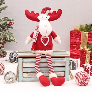 Detail of Christmas reindeer plush doll with striped legs sitting on a blue wooden box