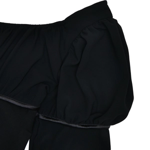 Détail des manches bouffantes à volants et liseré en satin sur cette robe noire