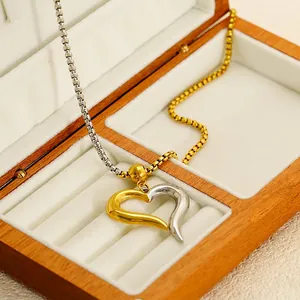 Two-tone gold and silver open heart pendant necklace on a premium wood gift box