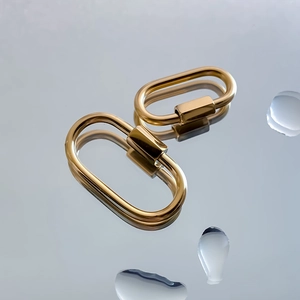 Detail of golden stainless steel oval screw clasps for necklaces and bracelets on mirror