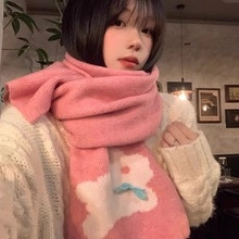 Close-up of pink knitted scarf with white patterns and blue bow tie on female model