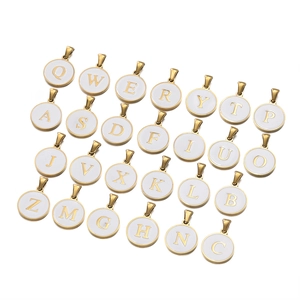 Macro view of gold stainless steel round pendants with white enamel and A-Z letters