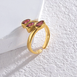 Macro detail of gold open ring with three oval pink cubic zirconia stones in a row