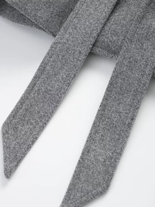 Close-up of gray wool fabric texture and adjustable belt tie on a double-breasted coat