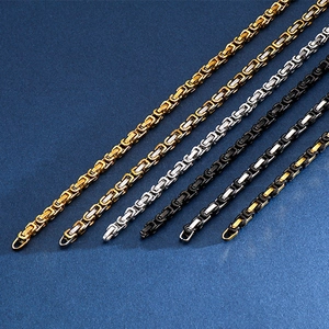 Flat lay of Byzantine emperor chain necklaces in gold, silver, and black metal finishes
