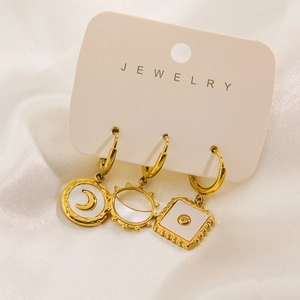 Dettaglio di tre orecchini in acciaio inossidabile placcato oro 14K con inserto in conchiglia