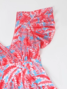 Detail of blue tropical print tankini with red palm leaf patterns and ruffled V-neckline