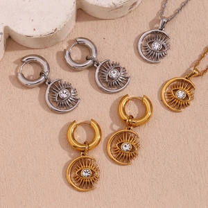 Flat lay of sun moon eye jewelry set with white rhinestones on beige texture