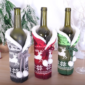 Knitted Christmas wine bottle covers featuring reindeer and snowflake patterns