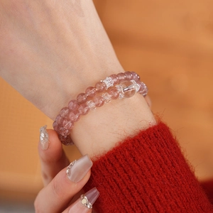 Detail of double-layer strawberry quartz bracelet with silver crown charm and pink crystal beads