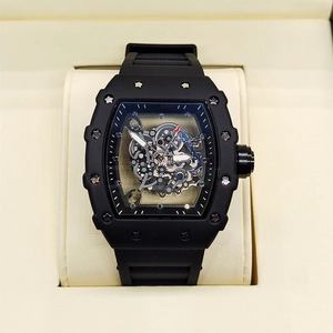 Detail shot of black tonneau-shaped skeleton watch with visible inner mechanical movement