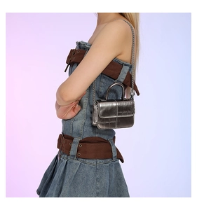 Close-up of silver crocodile embossed mini bag with metallic chain strap and top handle