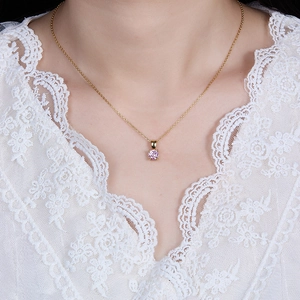 Close-up of a 925 silver necklace with a pink gemstone pendant on a female model