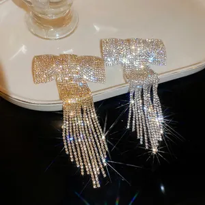 Boucles d'oreilles nœud en strass avec de longues franges en doré et argenté
