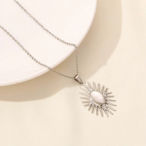 Detailed macro view of silver starburst pendant necklace on beige fabric background