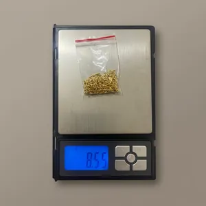 Macro shot of gold plated stainless steel necklace weighing 8.55 grams on digital scale