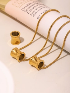 Gedetailleerd zicht op een gouden slangenketting gewikkeld om een cosmetische tube