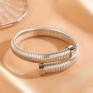 Détail du bracelet flexible spirale Tubogas argenté sur fond en soie orange