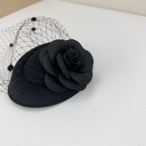 Detail of vintage black mini top hat fascinator with rose flower and polka dot mesh veil