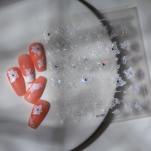 Detailed macro view of 3D embossed flower nail stickers with pearls and iridescent glitter