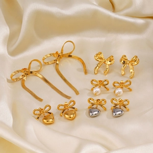 Parure de boucles d'oreilles nœuds et cœurs plaqués or 18 carats sur tissu en satin beige