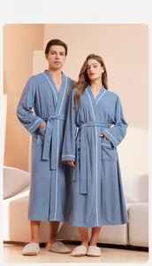 Detail of long-sleeved mist blue bathrobe with contrast piping and a waist tie for couples