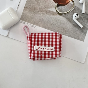 Detalle de la funda de lona a cuadros rojos y blancos para auriculares con cordón