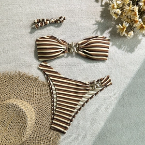 Detailed flat lay of striped bikini set with starfish buckles and matching scrunchie