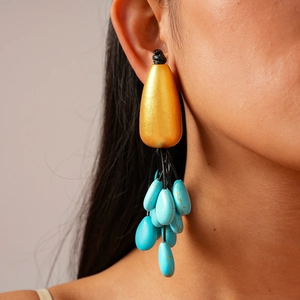 Detail of bohemian drop earrings with gold teardrop stud and turquoise beaded tassels