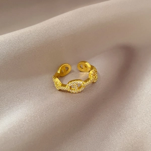 Adjustable gold chain ring with sparkling micro-pave crystals on champagne satin background