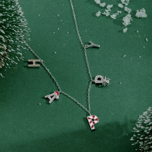 Macro detail of S925 silver HAPPY necklace with Christmas hat and candy cane charms
