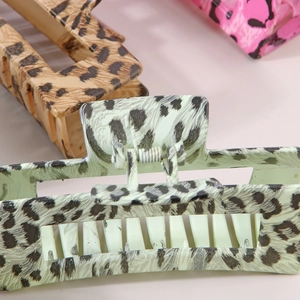 Detailed close-up of colorful leopard print hair claws with sturdy metal spring mechanisms