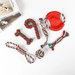 Flat lay of 7-piece Christmas red and green cotton rope dog toys and a pet flying disc