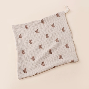 Detail of soft muslin cotton baby washcloth with brown rainbow pattern and hanging loop